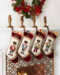 christmas stockings hanging from a fireplace with a wreath on top