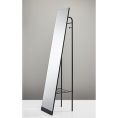 a tall mirror sitting on top of a metal stand