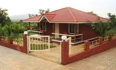 a brick house with a red roof and white railings