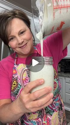 a woman pouring milk into a mason jar