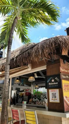 a tiki bar with chairs and a palm tree