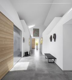 an empty hallway with benches and artwork on the walls