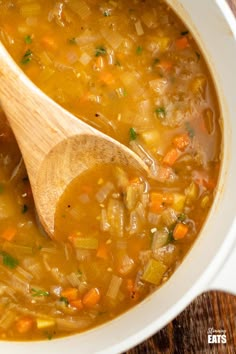 a white bowl filled with soup and a wooden spoon