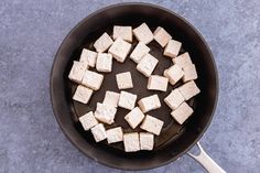 tofu cubes are being cooked in a skillet