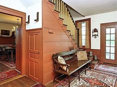 a living room filled with furniture next to a stair case in front of a door