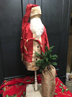 a santa clause suit sitting on top of a table next to a bag and christmas tree