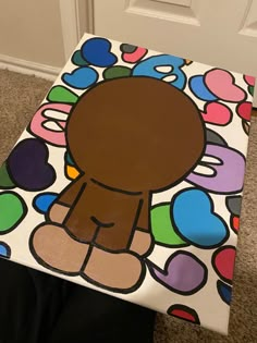 a child's foot sitting on the ground next to a painted stool