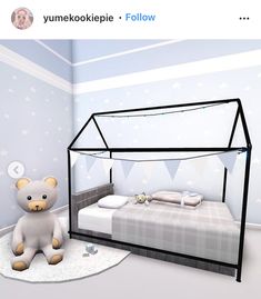 a white teddy bear sitting on top of a bed in a room with blue walls