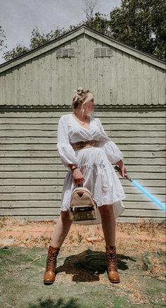 a woman in a white dress holding a light saber