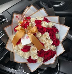 a bouquet of red and white roses in a car