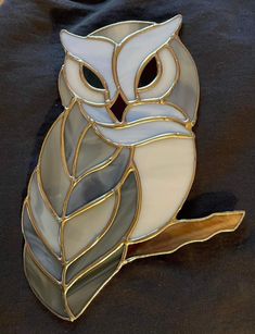 a stained glass owl sitting on top of a piece of cloth with its eyes closed