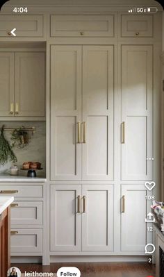 a kitchen with white cabinets and gold pulls on the doors is shown in an instagram