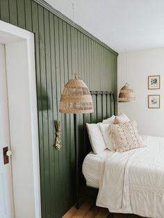 a white bed sitting in a bedroom next to a green wall