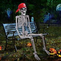 a skeleton sitting on a park bench with pumpkins