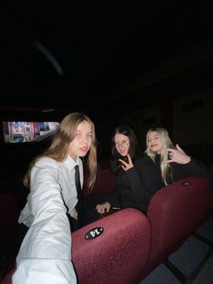 three young women sitting in a movie theater