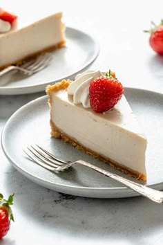 two plates with slices of cheesecake and strawberries on the top one has a fork