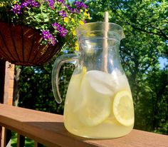 a pitcher filled with lemonade sitting on top of a wooden table