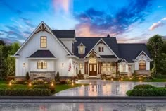 a large white house with lots of windows on it's front porch and landscaping