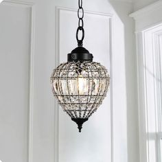 a light fixture hanging from the ceiling in a room with white walls and windows behind it