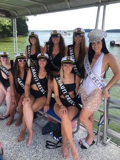 a group of women in bathing suits and hats posing for a photo on a boat