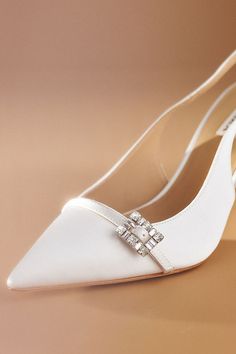 The Badgley Mischka Annmarie Slingback Stiletto Pumps provide a sophisticated lift, while the pointed toe elongates your foot and the adjustable slingback strap ensures a comfortable fit, highlighted by a stunning jeweled vamp buckle for a touch of sparkle. | Annmarie Slingback Stiletto Pumps by Badgley Mischka in White, Women's, Size: 8, Leather/Satin at Anthropologie Bridal Shoes Badgley Mischka, Bradley Mischka Wedding Shoes, Badey Mischka Wedding Shoes, Chic White Slingback Pumps With 4-inch Heel, White Slingback Pumps With 4-inch Heel For Evening, White Pumps, Stiletto Pumps, Badgley Mischka, 50 Fashion