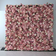 a large pink and white flower covered wall