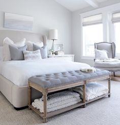 a bedroom with a large bed and white furniture