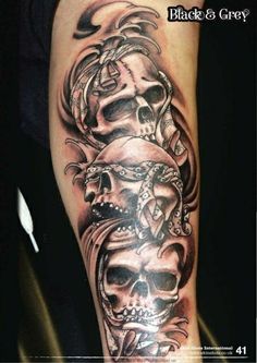 a man's arm with skulls on it and the words black and grey written in white