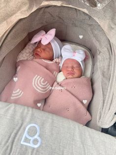 two newborn babies are sleeping in their crib with pink blankets and bows on their heads