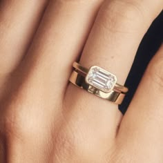 a woman's hand with a ring on it and a diamond in the middle