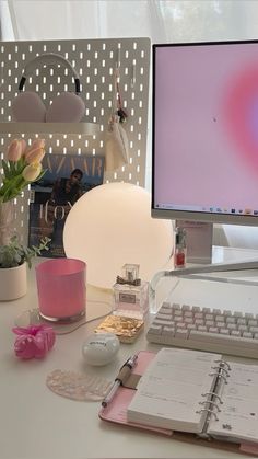 a desktop computer sitting on top of a white desk next to a keyboard and mouse