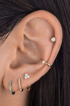 a close up of a person wearing ear rings and piercings on their left side