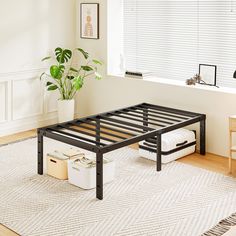 a black metal bed frame sitting on top of a wooden floor next to a window