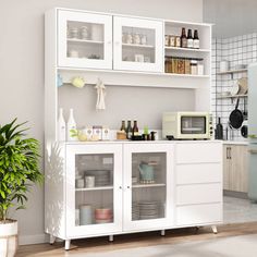 a kitchen with white cupboards and shelves filled with dishes on top of each cabinet