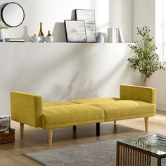 a living room with a yellow couch and coffee table on the floor next to a white wall