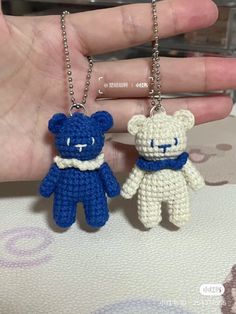 two small crocheted teddy bears are being held in the palm of someone's hand