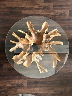 a glass table topped with wooden pieces on top of a hard wood flooring area