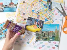 a person is holding a bottle of sunscreen next to a map and some scissors