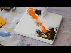 an orange and black painting is being worked on