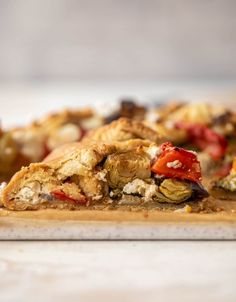 a close up of a pizza on a cutting board with other food items in the background