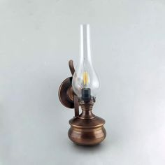 an old fashioned wall light with a glass bulb on the front and back side, against a white background