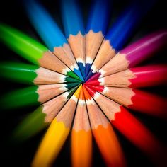 colored pencils arranged in a circle on a black background