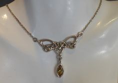 A fine solid silver and citrine set celtic styled necklace . the pendant part of the necklace is in form of a celtic  knot with a marquise cut citrine gemstone dangling from centre. the pendant part measures 3.8cm wide x 3.5cm drop. has a silver link chain attached to either side, overall length 18 inches. looks very stylish when worn. stamped 925 for silver. Silver Link Chain, Citrine Gemstone, Sustainable Jewelry, Marquise Cut, Celtic Knot, Link Chain, Pendant Necklaces, Jewelry Inspiration, Citrine