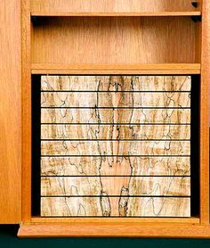 a wooden cabinet with metal bars on the front and bottom shelves, inlaid with wood