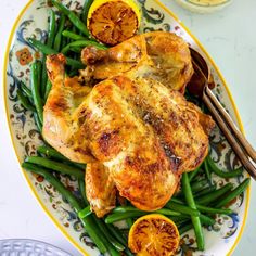 a plate with chicken, green beans and orange slices