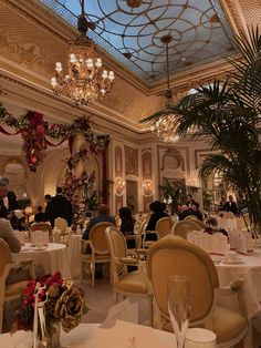 the dining room is decorated for christmas with white tablecloths and gold chairs