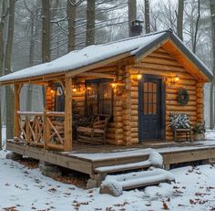 a small log cabin in the woods with lights on it's porch and deck