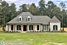 a white house with black shutters in front of some trees and grass on the ground