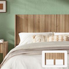 a bed with white sheets and pillows in a green room next to a wooden headboard