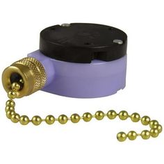 a purple and black object with gold balls on it's end, next to a ball chain